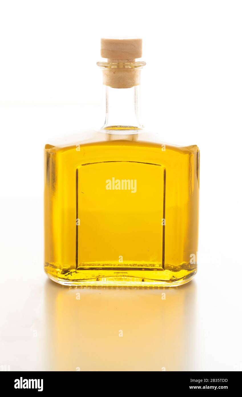 Flasche mit Olivenöl isoliert. Transparente Glasflasche mit Korkstopfen isoliert vor weißem Hintergrund. Natives Olivenöl extra Qualität, Gold Stockfoto