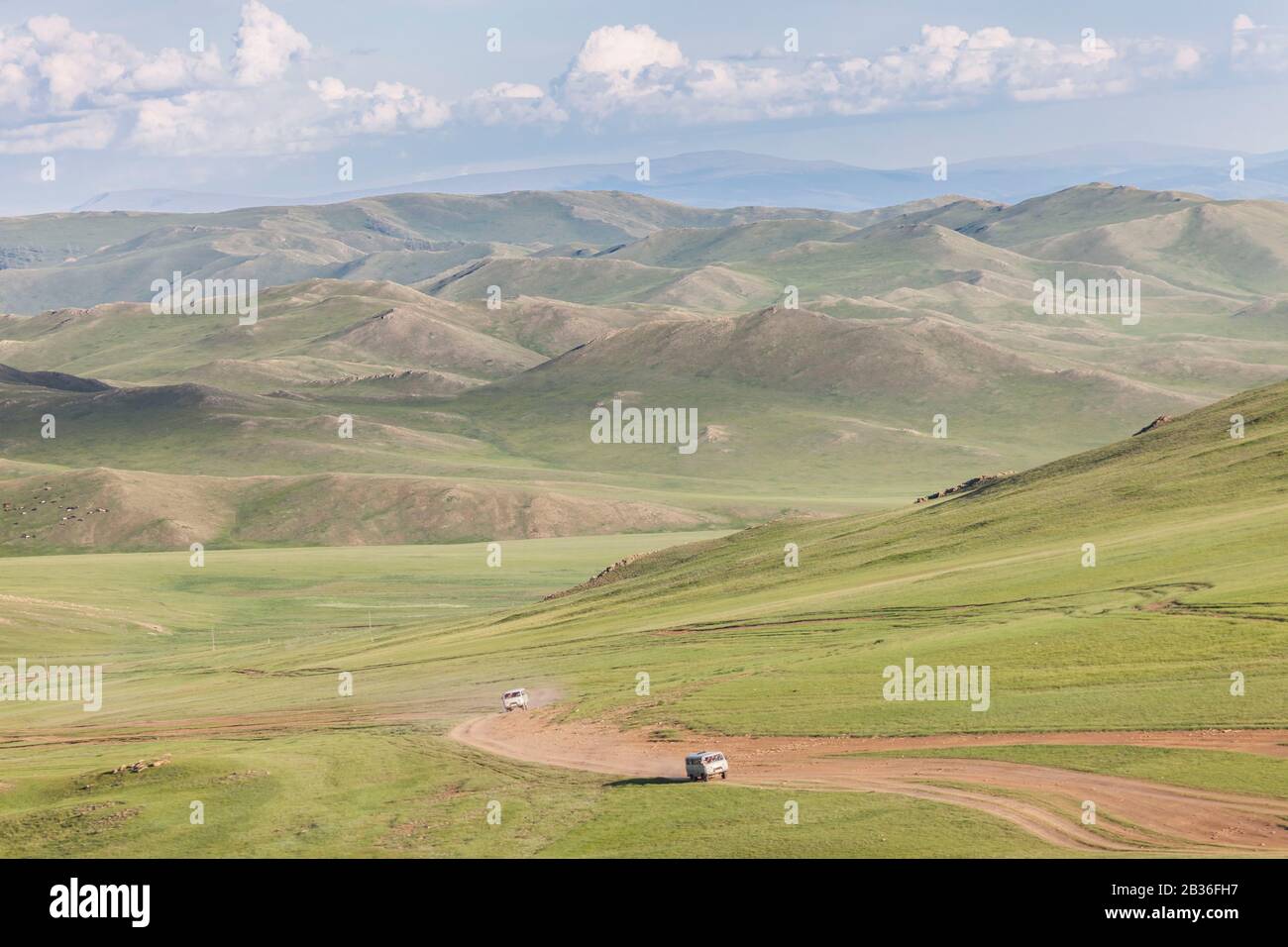 Die Mongolei, die Provinz Khovsgol, die Steppenlandschaft und die grasigen Berge bei Moron, zwei russische Kleinbusse UAZ 452 auf einer staubigen Straße Stockfoto