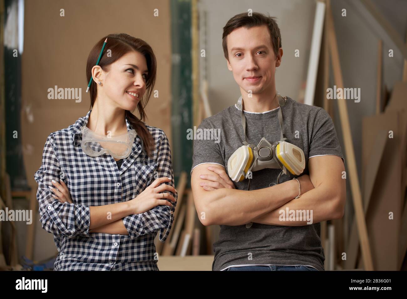 Die Tischler mit gekreuzten Armen in der Werkstatt mit Blick auf die Kamera verbinden Stockfoto