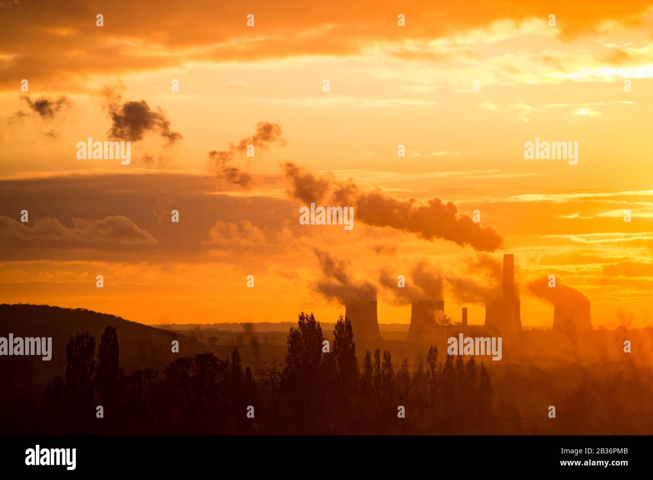 Silhouette des Kohlekraftwerks bei Sonnenuntergang, die Kohlenstoff ausstrahlt, Großbritannien. Verschmutzung durch fossile Brennstoffe, die den Klimawandel verursacht. Klimaschutz. Ratcliffe-on-Soar Stockfoto