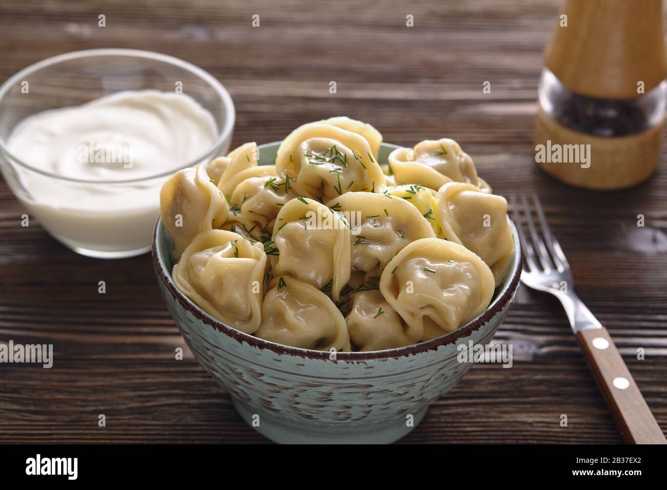 Platte aus traditionellen russischen Knödel, Ravioli auf dunklem Holzhintergrund. Hausgemachte Speisen. Stockfoto