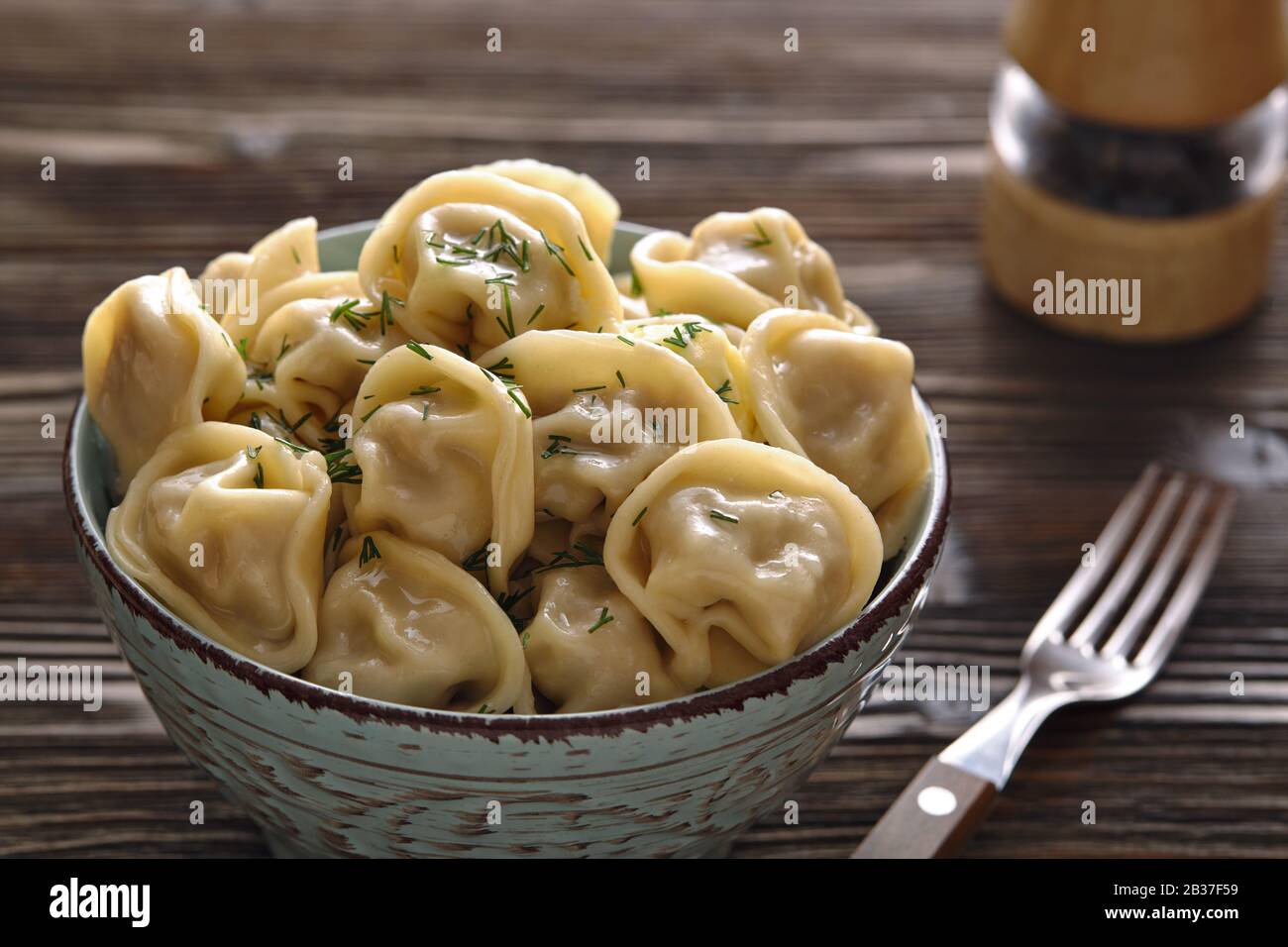 Platte aus traditionellen russischen Knödel, Ravioli auf dunklem Holzhintergrund. Hausgemachte Speisen. Stockfoto