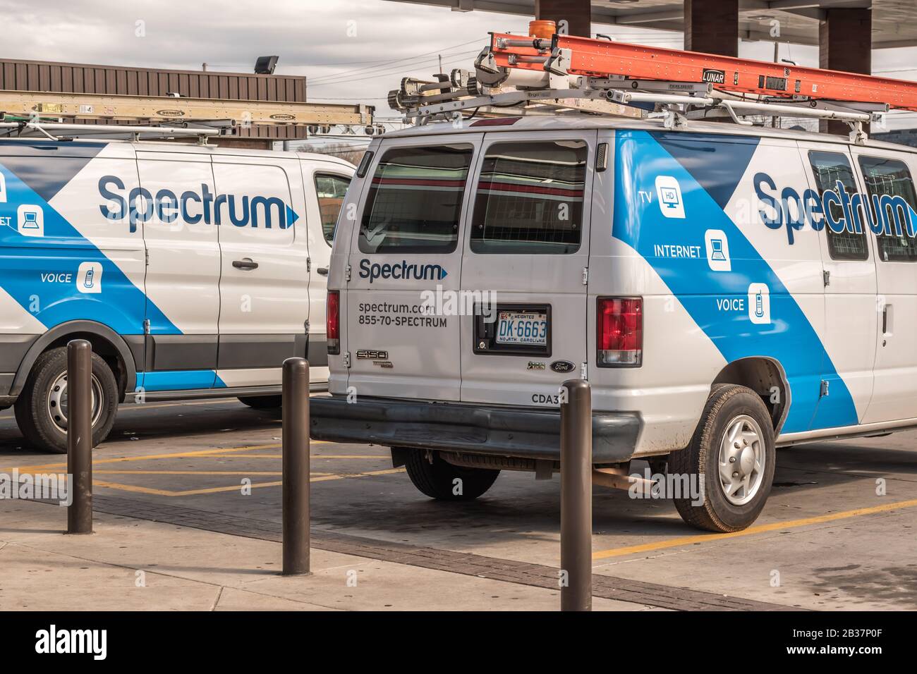 Horizontale mittlere Nahaufnahme von zwei geparkten 'Spectrum'-Transportern mit blau-weiß lackierten Markenlogos. Stockfoto