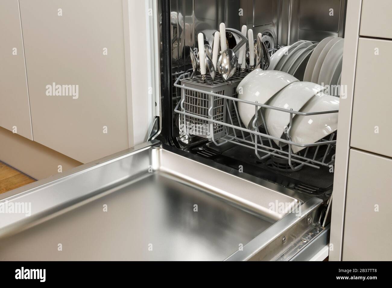Eine kompakte Geschirrspülmaschine mit weißem Geschirr in einer modernen Küche Stockfoto