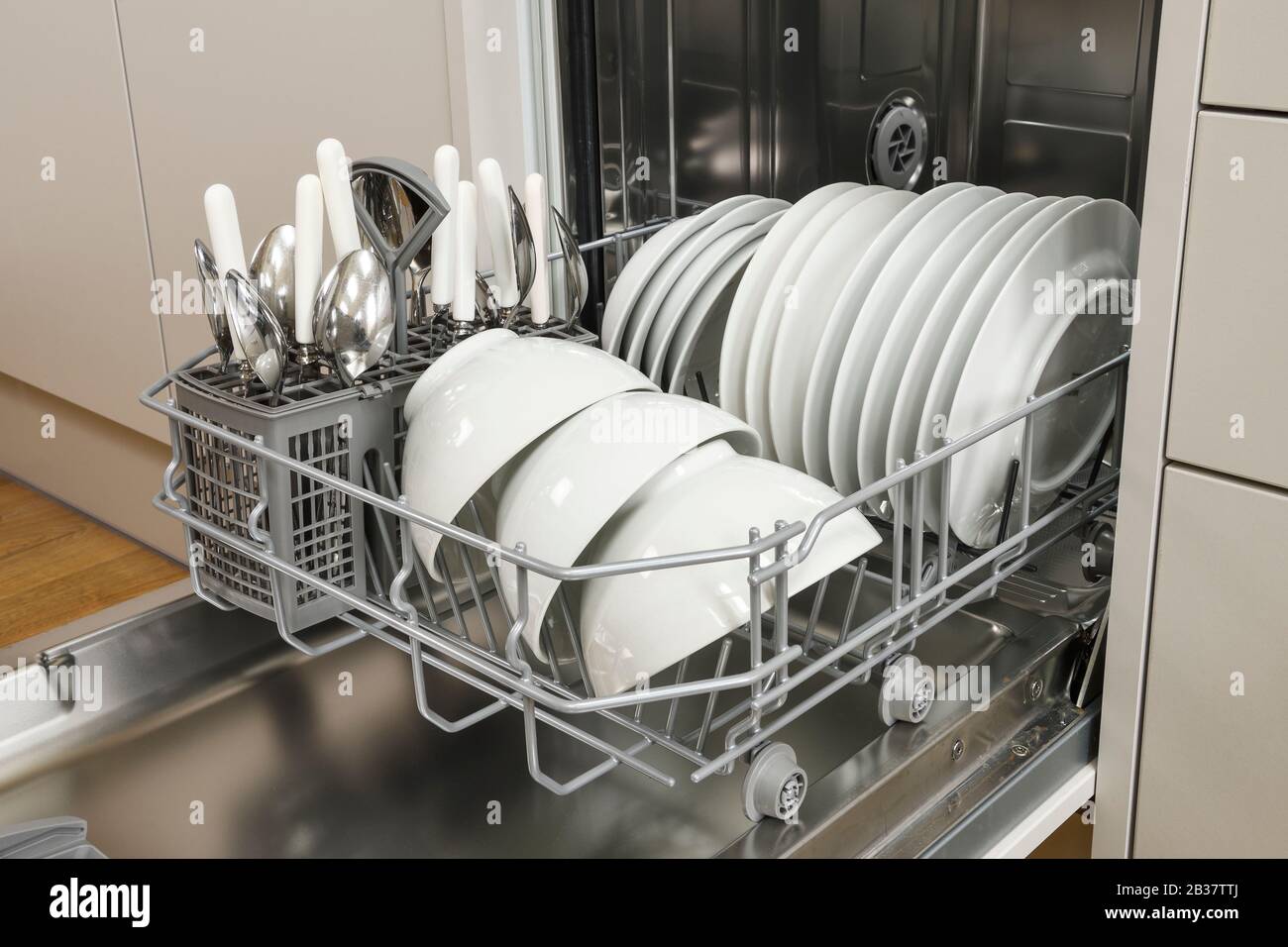 Eine kompakte Geschirrspülmaschine mit weißem Geschirr in einer modernen Küche Stockfoto