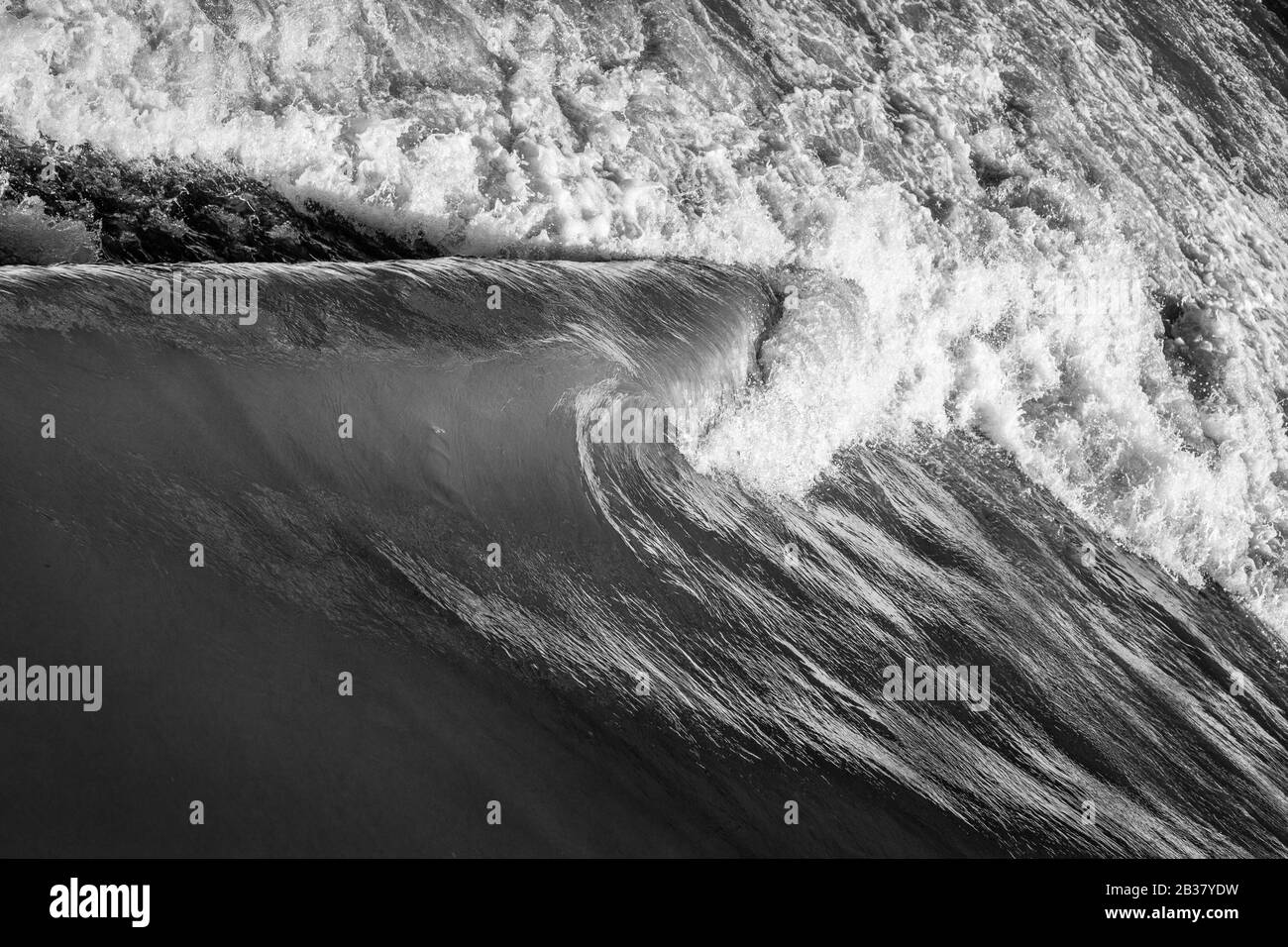 Wasser hetzt über ein Wehr. Stockfoto