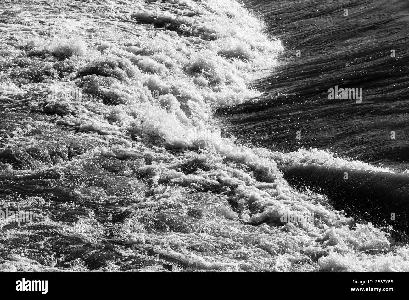 Wasser hetzt über ein Wehr. Stockfoto