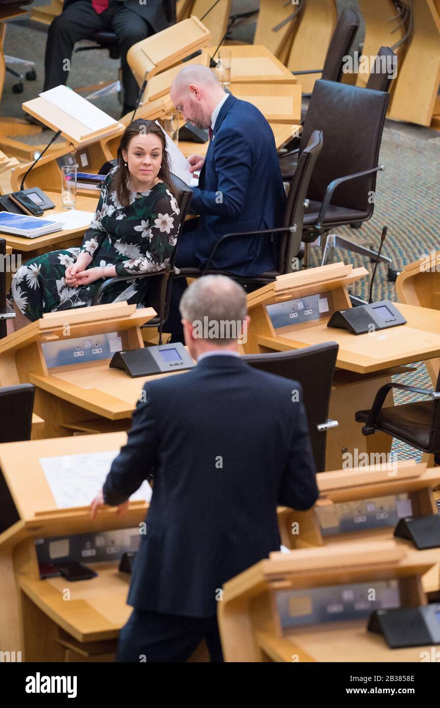 Edinburgh, Großbritannien. März 2020. Abgebildet: (Oben links) Ben MacPherson MSP - Minister für öffentliche Finanzen und Migration; (oben rechts), Kate Forbes MSP - Kabinettsministerin für Finanzen; (unten vorne, stehend), Willie Rennie MSP - Anführer der Scottish Liberal Democrats Party. Debatte der schottischen Regierung: Szenen der schottischen Ratenentschließung in der Debattierkammer des schottischen Parlaments. Kredit: Colin Fisher/Alamy Live News Stockfoto