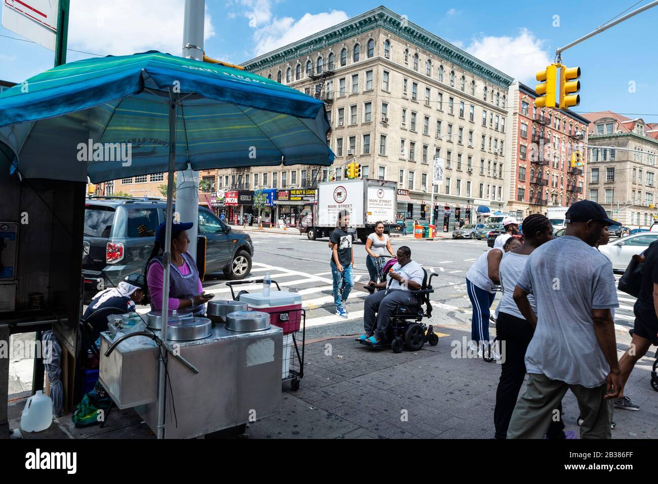 New York City, USA - 3. August 2018: Lebensmittel-Stall in der Straße mit seinem Anbieter und den Menschen auf einer Straße in Harlem, Manhattan, New York City, USA Stockfoto