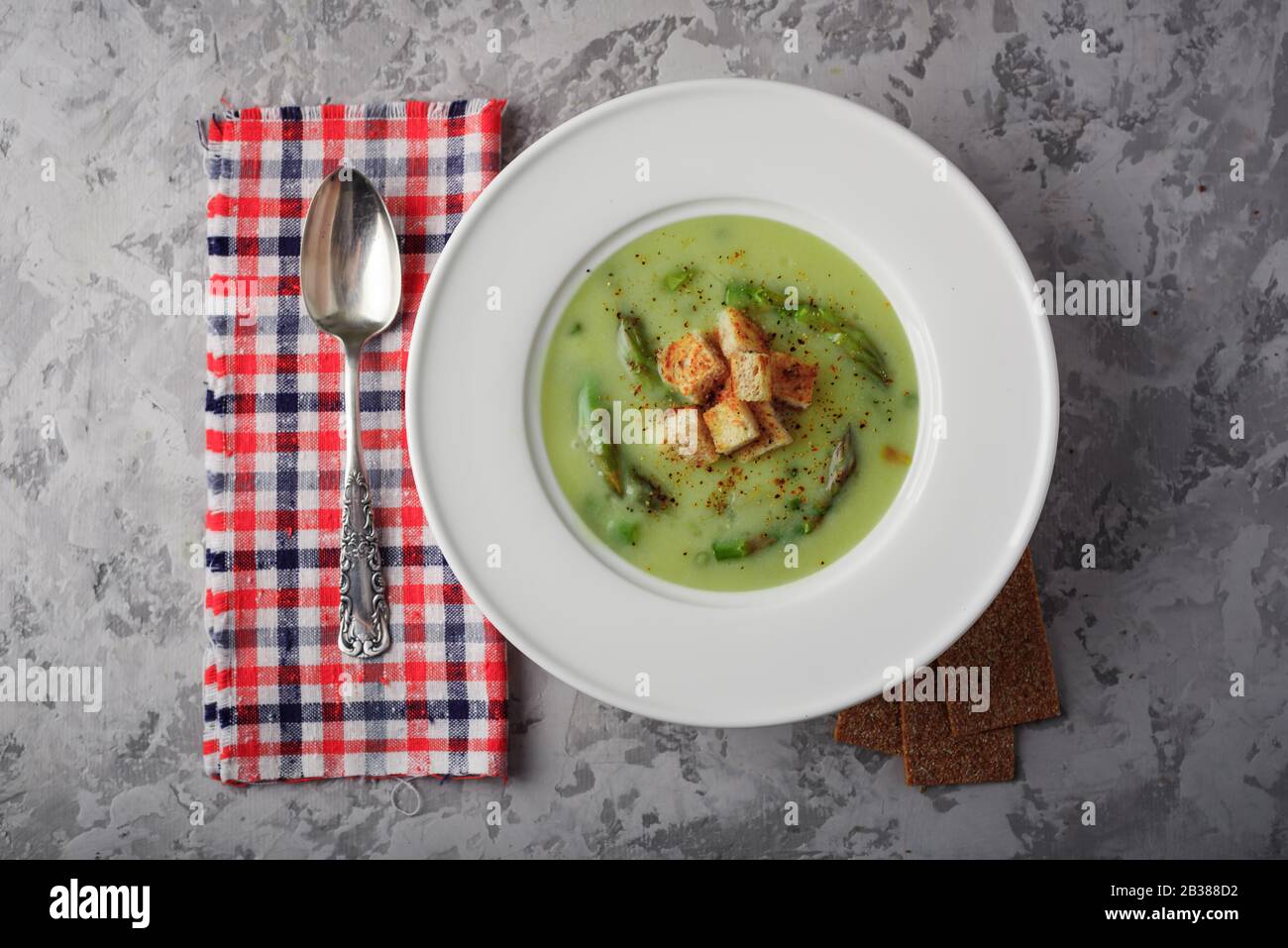 Grüner Spargel Suppe mit Crackern in Weiß Schüssel Nahaufnahme. Essen Fotografie Stockfoto