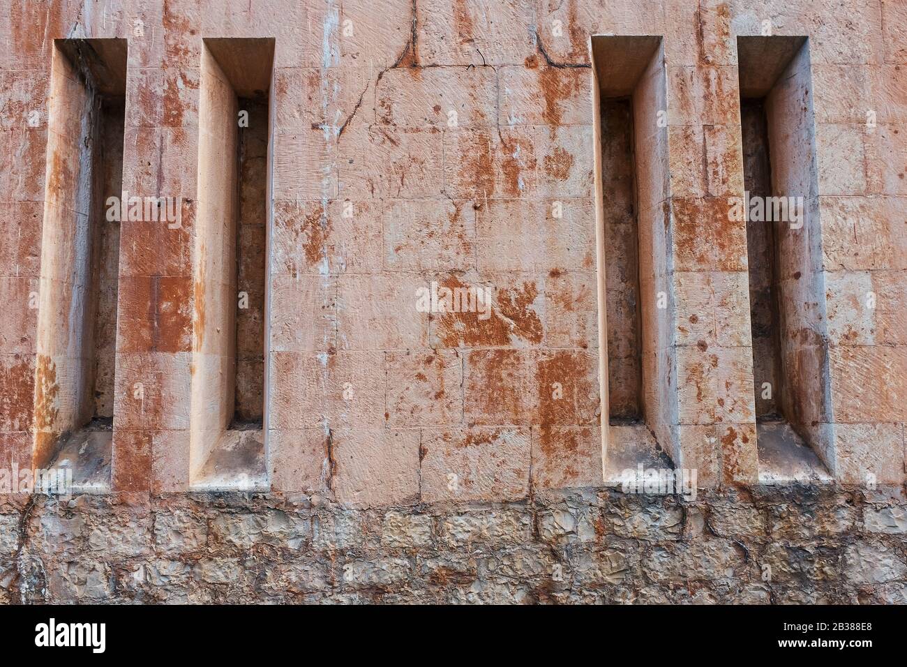 Die Burgmauer mit schmalen senkrechten Fenstern des Tempels. Vollbild als Hintergrund Stockfoto