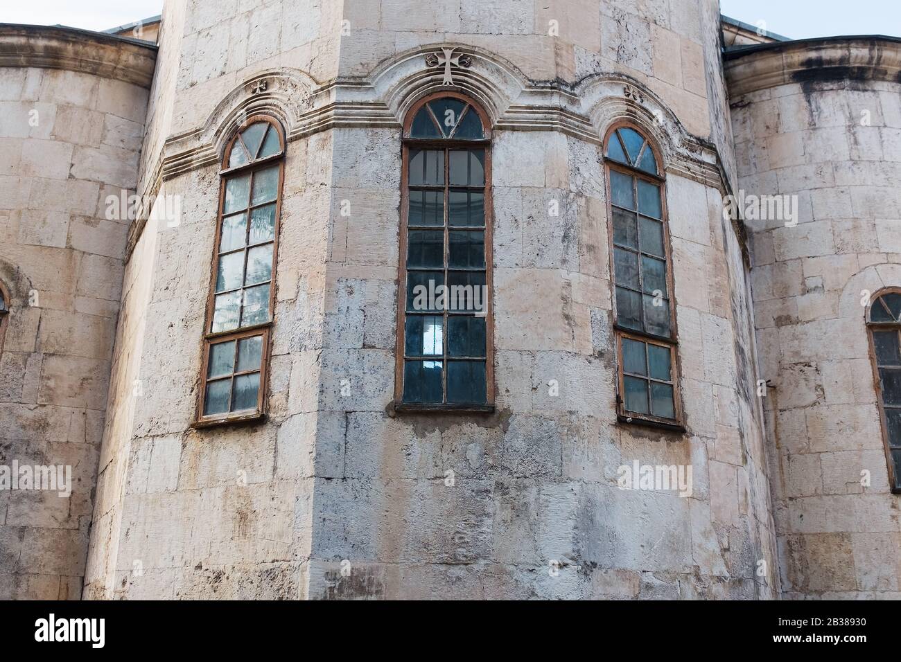 Schmale Senkrechte blaue Fenster der Kirche, die Burg mit einer Mauer aus grauem alten Backstein. Element der historischen Architektur Stockfoto