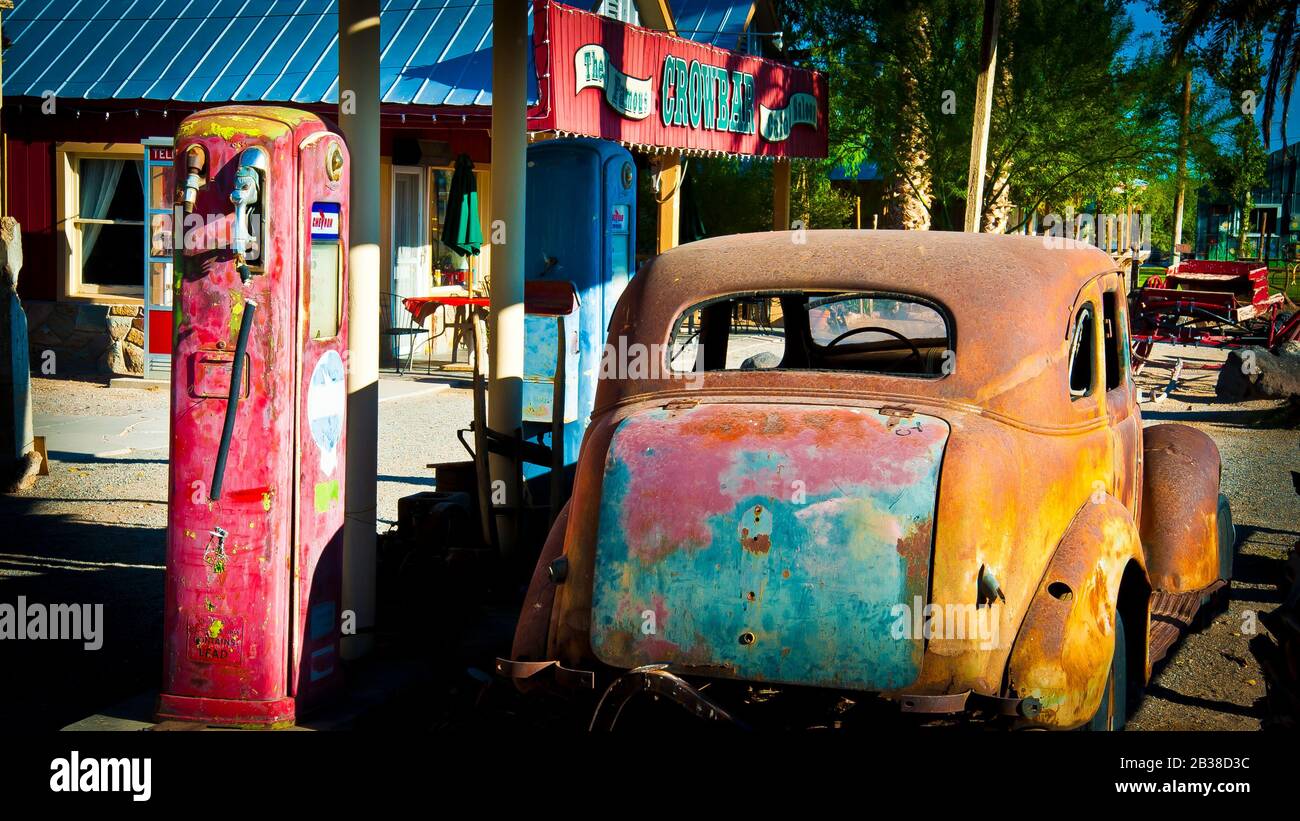 Ende des fossilen Kraftstoffs und des Verbrennungsmotors, Auto aus den alten 1930er Jahren steht gegenüber redundanten Benzinpumpen in der Tankstelle, Kalifornien, USA, Stockfoto