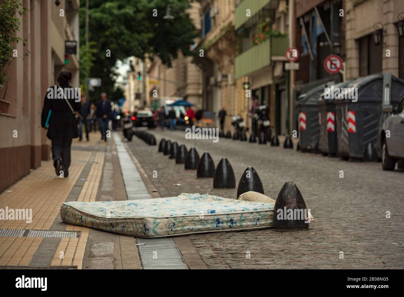 Matratze mit Obdachlosenkissen, auf der Straße aufgegeben. Begriff der Armut und der Entstellung Stockfoto