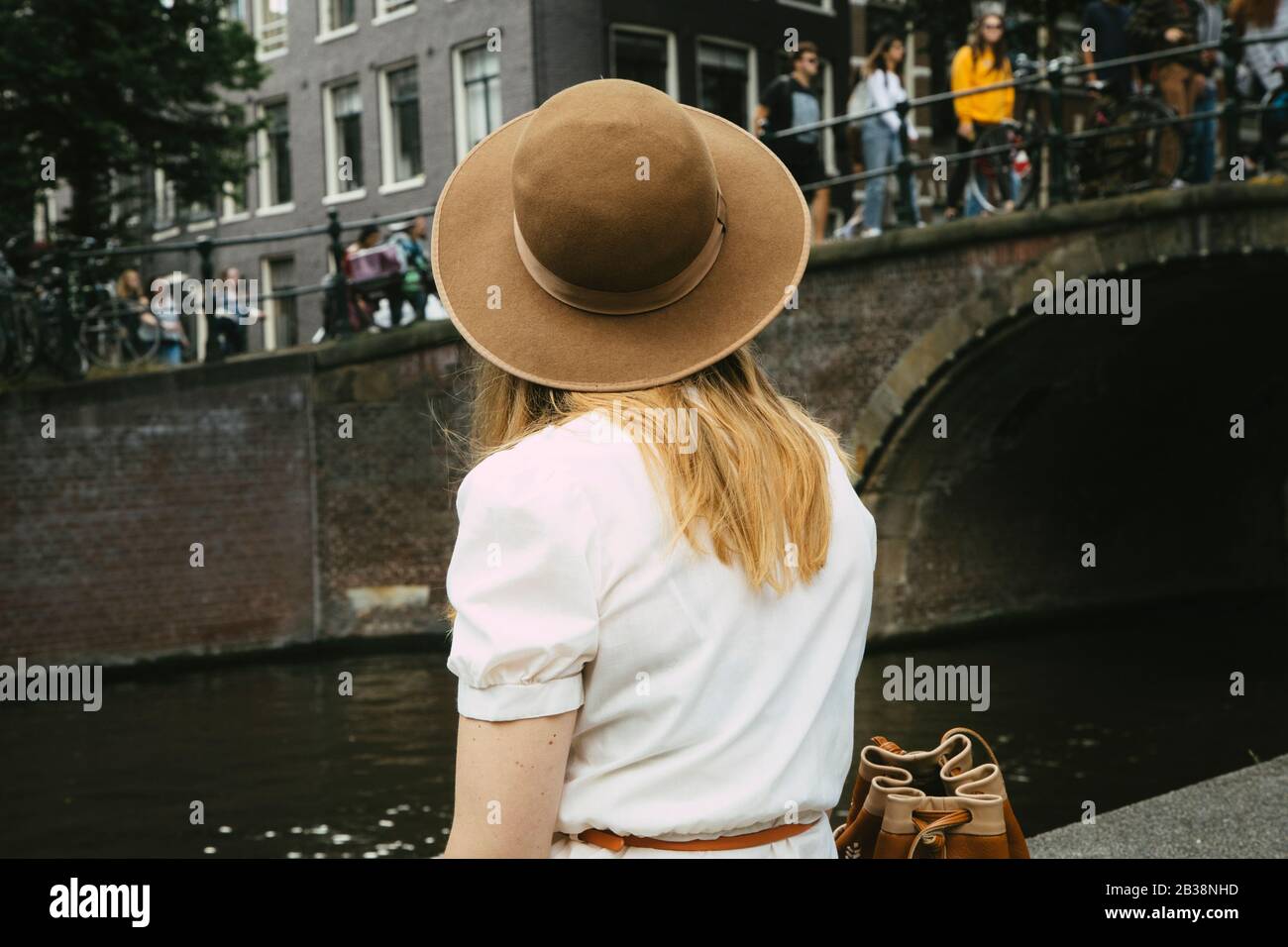 Frau in Hut mit Blick auf Kanal und Stadt Stockfoto