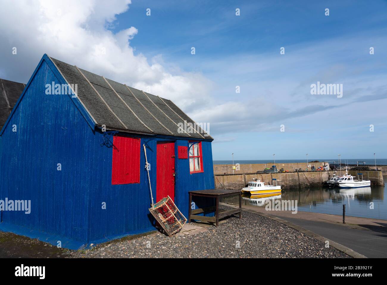 Bunte Holzhütte am Hafen im Fischerdorf St Abbs an der Nordseeküste in Scottish Borders, Schottland, Großbritannien Stockfoto