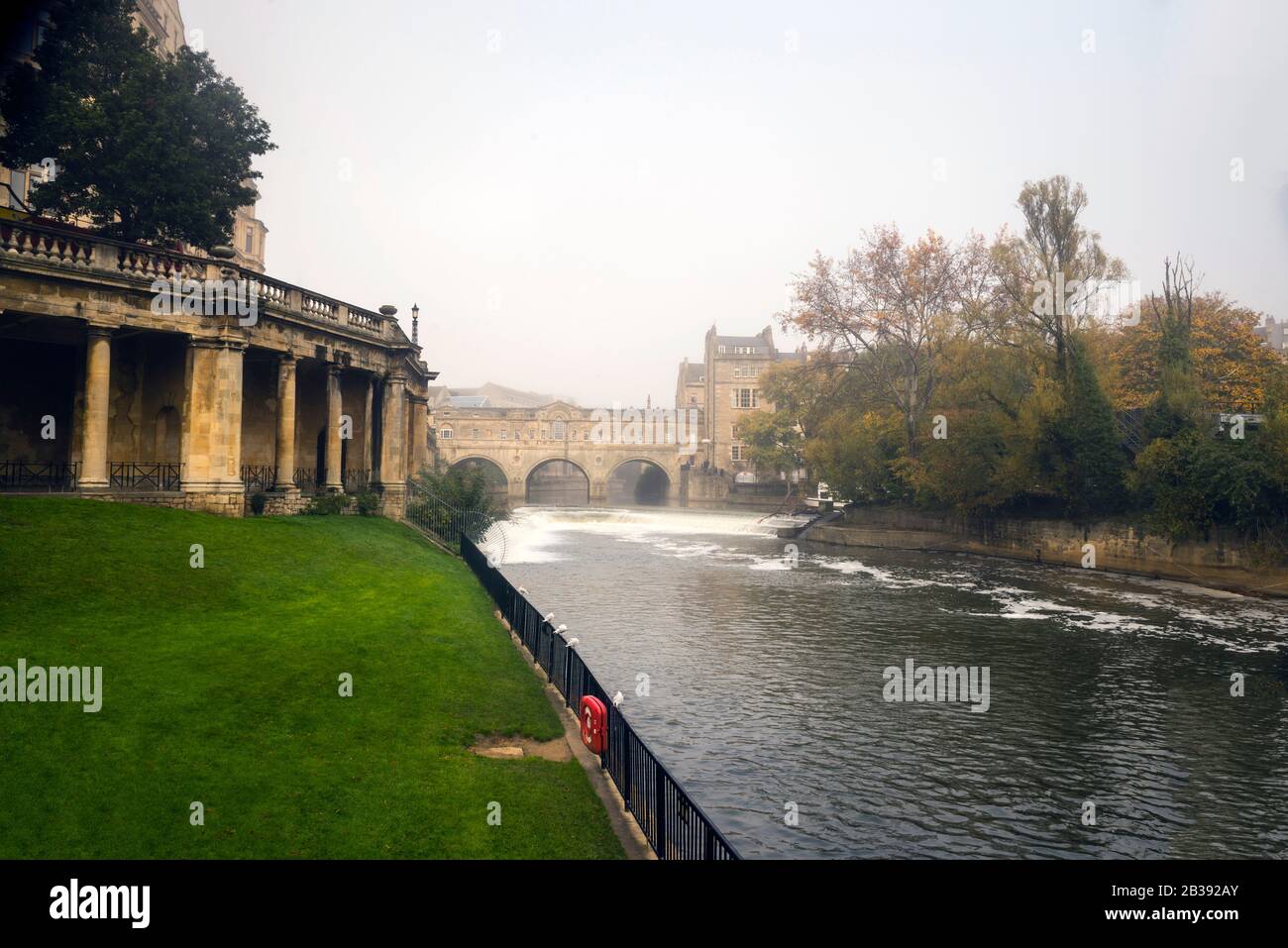 Erbaut aus Bath Stone, was ursprünglich das Empire Hotel war, ziehen anmutige Säulen den Blick auf das Wehr und die Pultney Bridge in Bath, England. Stockfoto