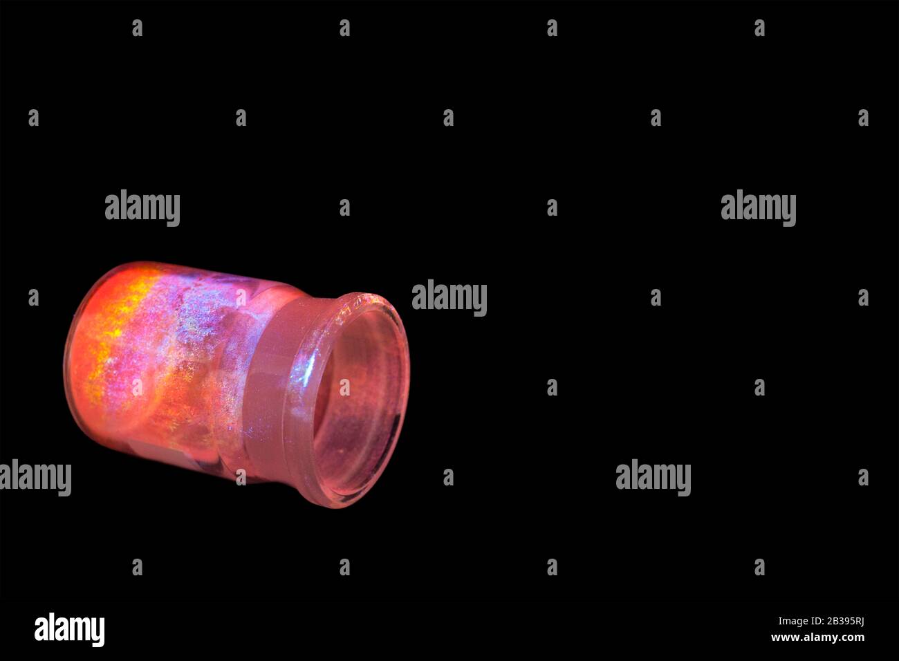 Leuchtende organische Materialien in Form eines Pulvers in einer Glasflasche. Stockfoto