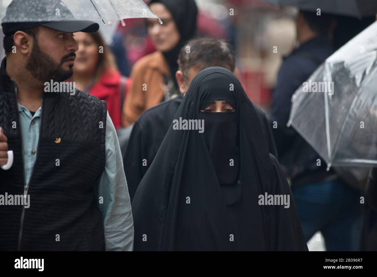 Istanbul: Muslimisches Paar, das unter dem Regen auf der Istiklal-Allee spazieren geht. Türkei Stockfoto