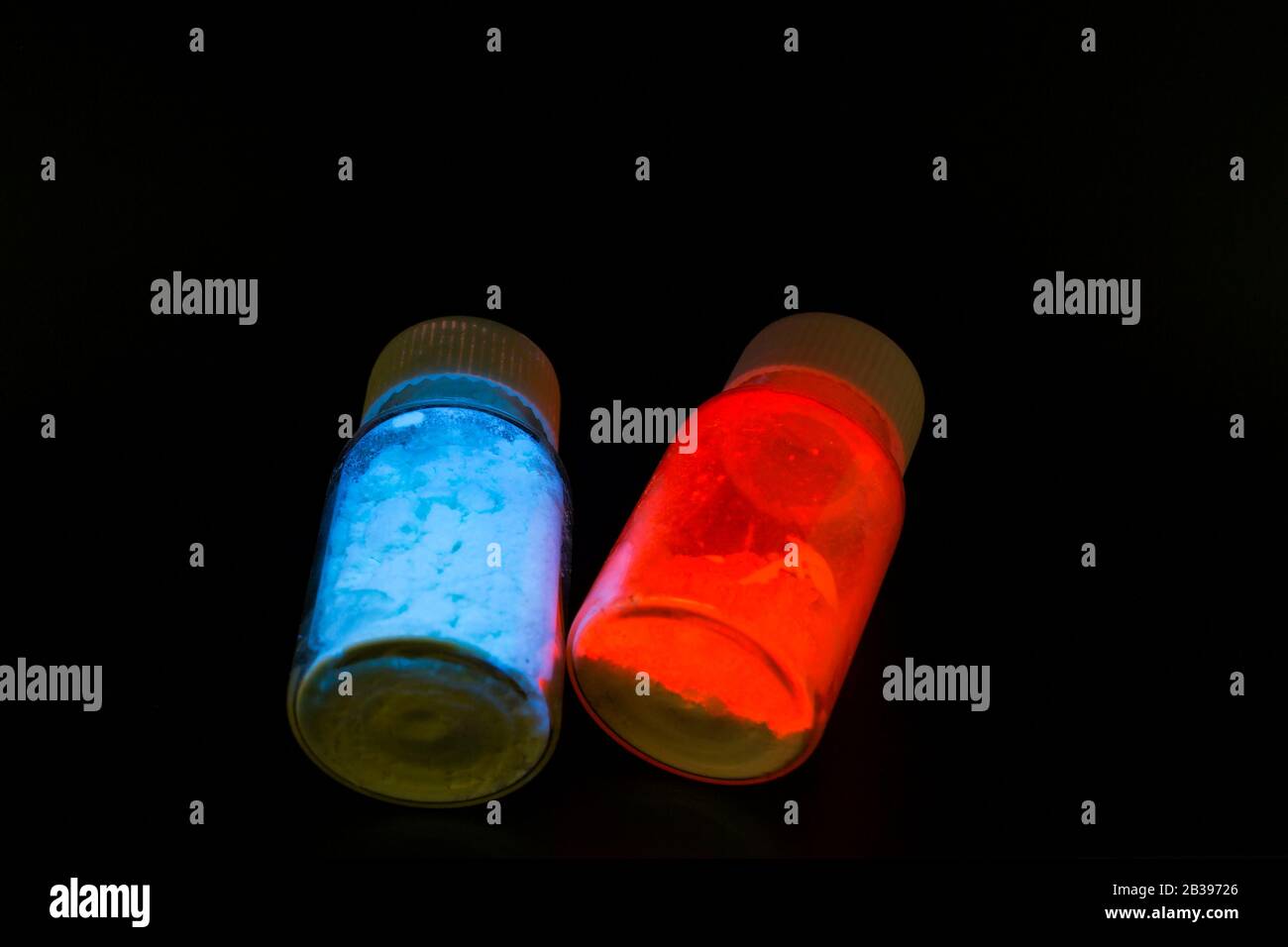 Leuchtende organische Materialien in Form eines Pulvers in zwei Glasflaschen. Stockfoto