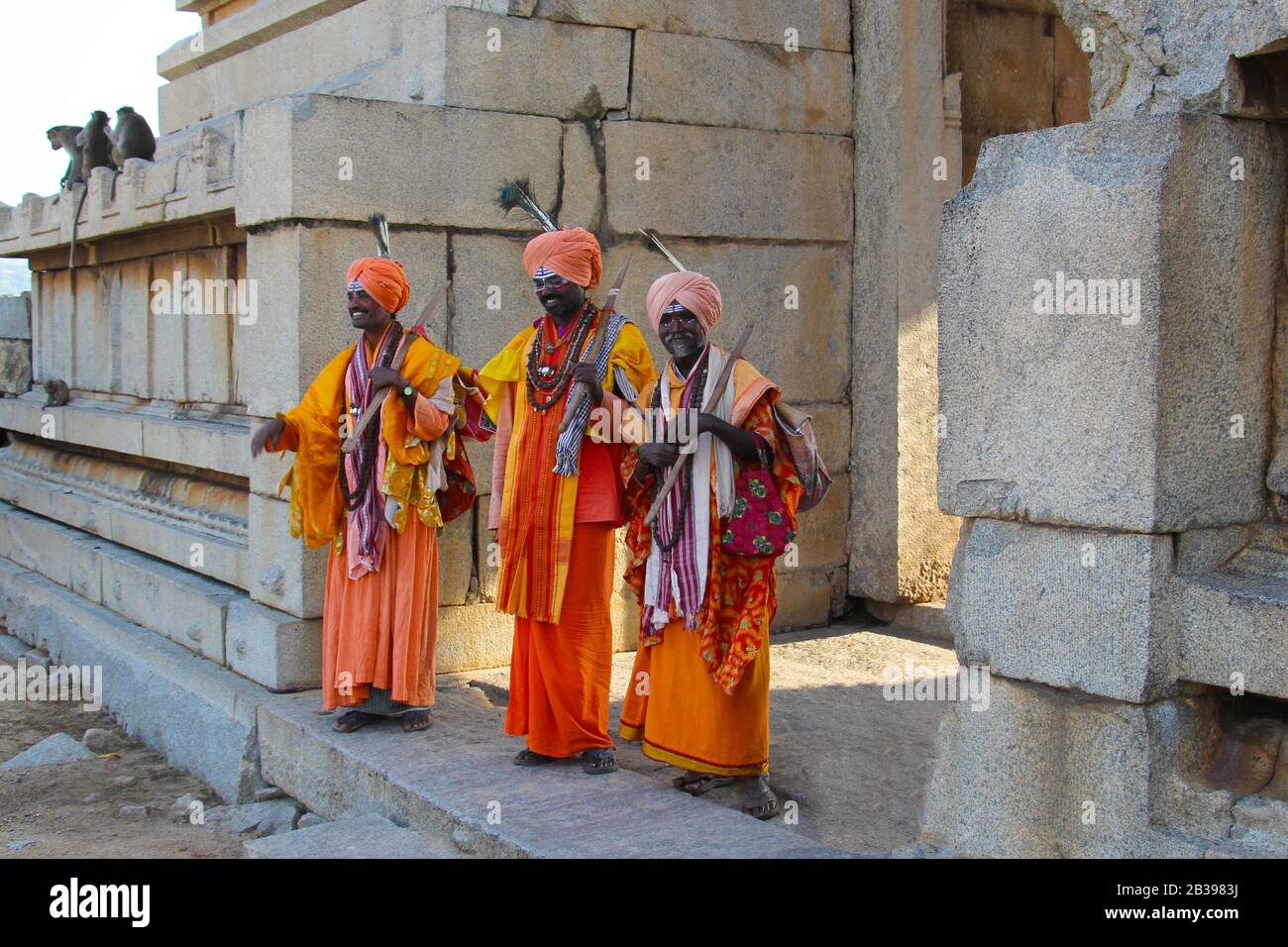 PUSHKAR, INDIEN - 12. NOVEMBER 2015 : drei Männer in festlichen Kostümen vor dem Hintergrund der alten Mauern des Tempels posieren Stockfoto