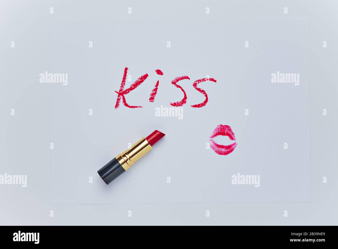 TEXT-KUSS-Zeichnung und Spur von Kuss durch roten Lippenstift auf weißem Blatt. Skizze in weißer Kulisse. Romantischer Hintergrund am Valentinstag. Einfache Form. Stockfoto