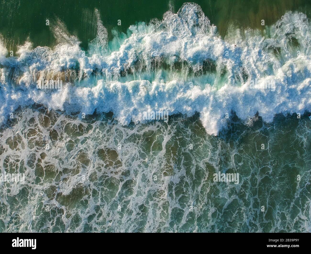 Luftaufnahme von einer großen Welle, die in einem Strand zusammenbricht. Drohnenansicht Stockfoto