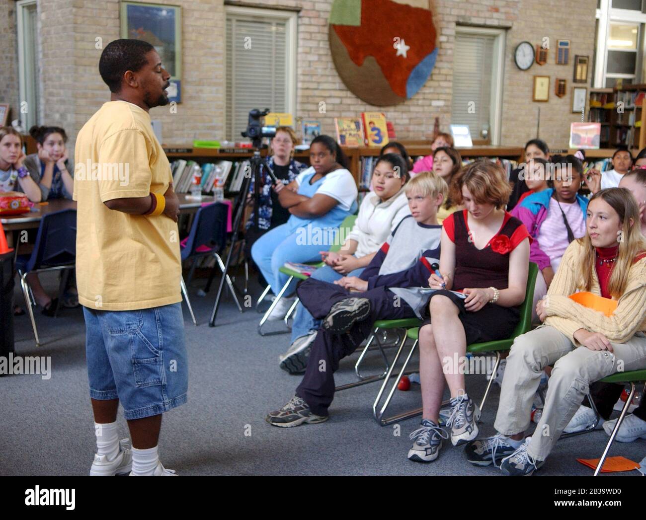 Austin Texas USA, um 2004: Schwarzer Dichter erklärt Wettbewerbsregeln vor dem Start des ersten „Poetry Slam“ für Schüler der 7. Klasse der Fulmore Junior High School in der Schulbibliothek. ©Bob Daemmrich Stockfoto