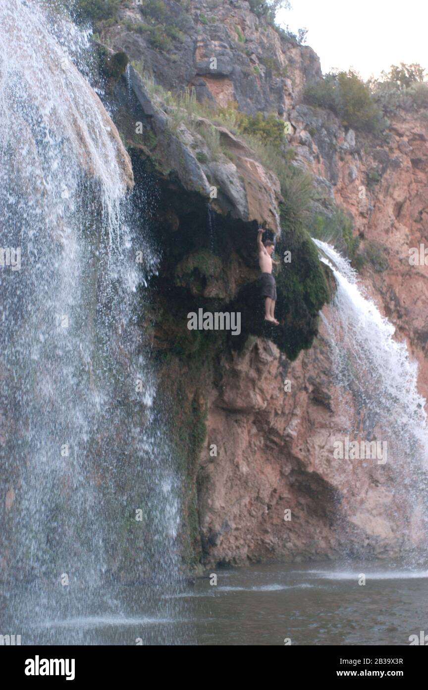 Llano County, Texas August, 2004: Teenagerjunge springt ohne Erlaubnis des Grundbesitzers von einem Wasserfall, ein gefährlicher Stunt. Nein, HERR ©Bob Daemmrich Stockfoto