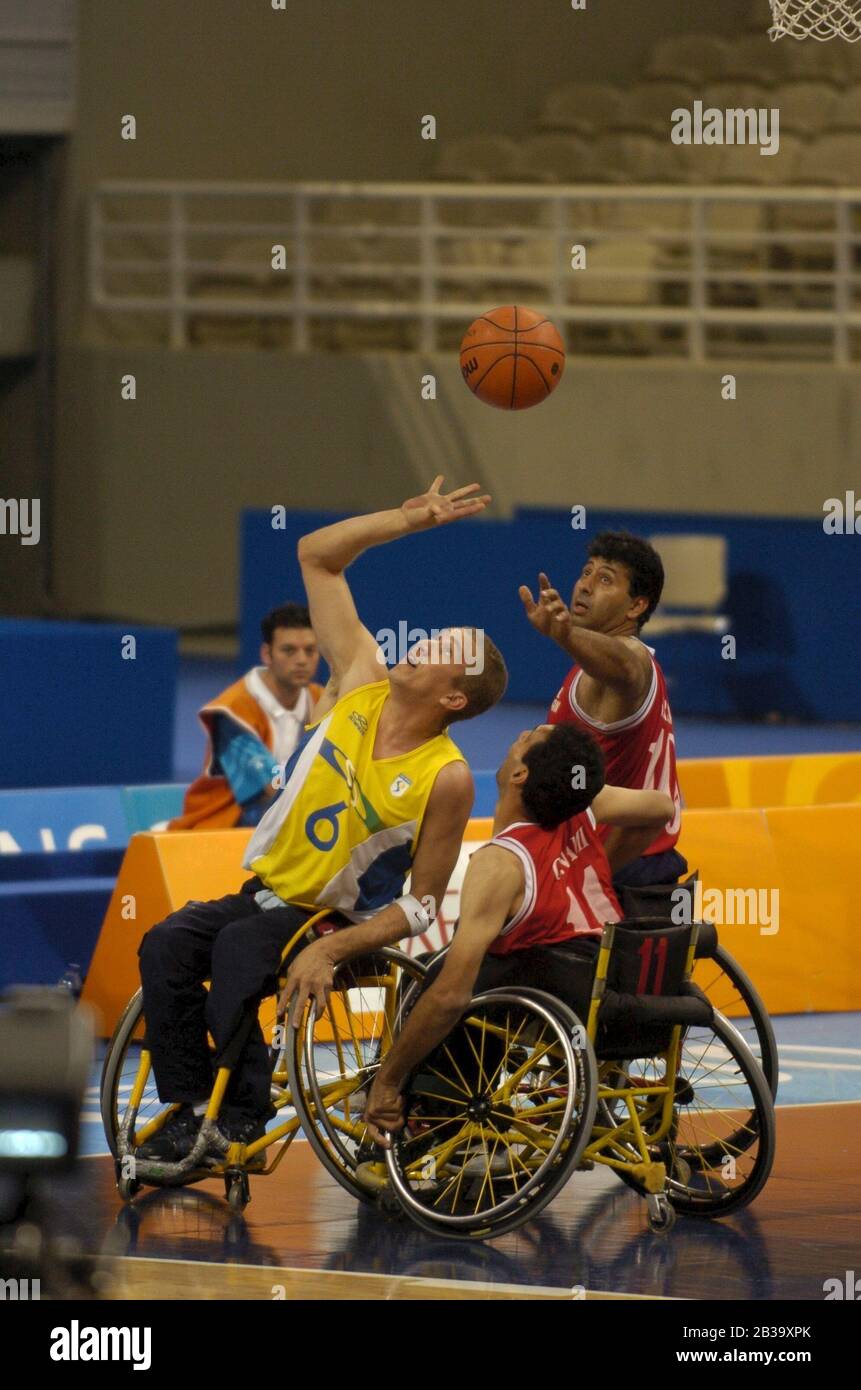 Athen, Griechenland 26 SEP 04: Paralympics Männer Rollstuhl Basketball Aktion zwischen Brasilien (gelb) und Iran (rot). ©Bob Daemmrich Stockfoto