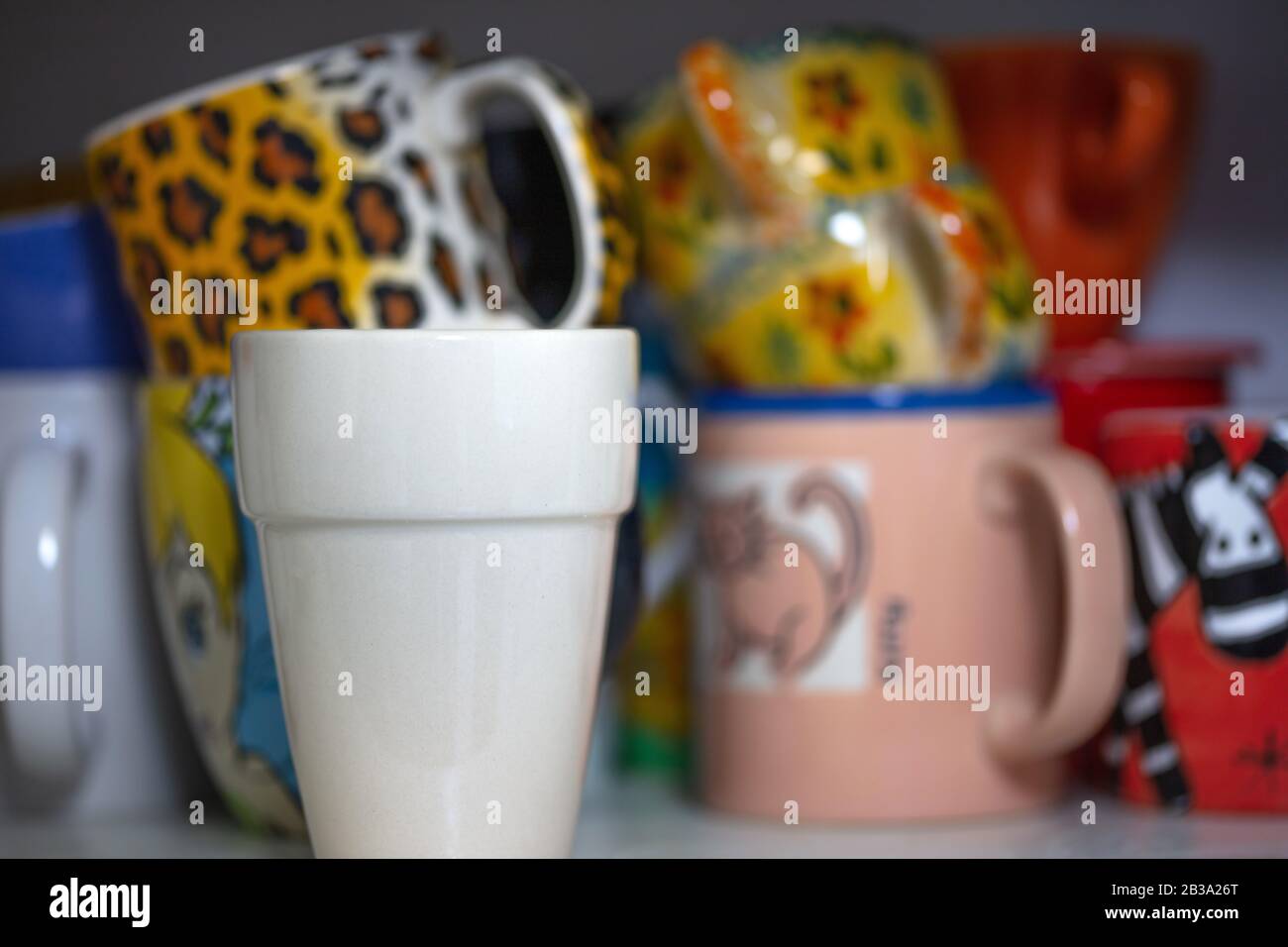 Verschiedene bunte Teetassen in einem Schrank Stockfoto