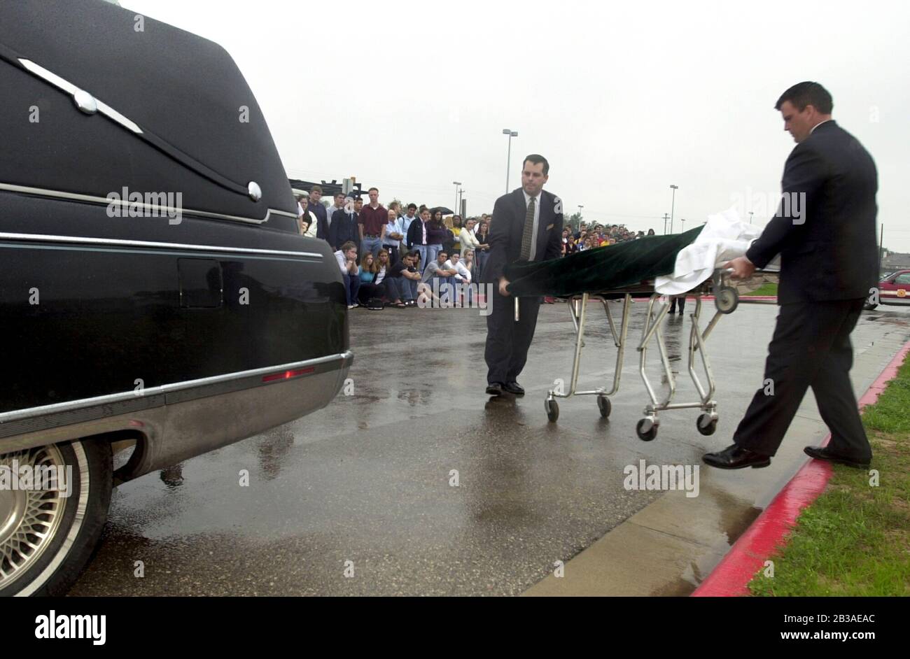 Cedar Park, Texas 07 MAR 2001: Eine von Studenten geführte Produktion von „Shattered Dreams“ mit dem simulierten Drama eines Teenagerunfalls, der im Rausch war (DUI), komplett mit Polizisten, Krankenwagen, medizinischem Evakuierungshubschrauber und einem Leichenwagen, wurde an der Cedar Park High School inszeniert, um Schülern zu helfen, nicht zu trinken und zu fahren. An der Produktion nahmen Dutzende von Studenten als Unfallopfer, Berater und weinende Verwandte Teil, darunter eine Beerdigungs-Produktion mit Schatullen und trauernden Eltern. Hier laden Hausangestellte einen „toten“ Studenten in einen Leichenwagen außerhalb der Schule. ©Bob Daemmrich Stockfoto