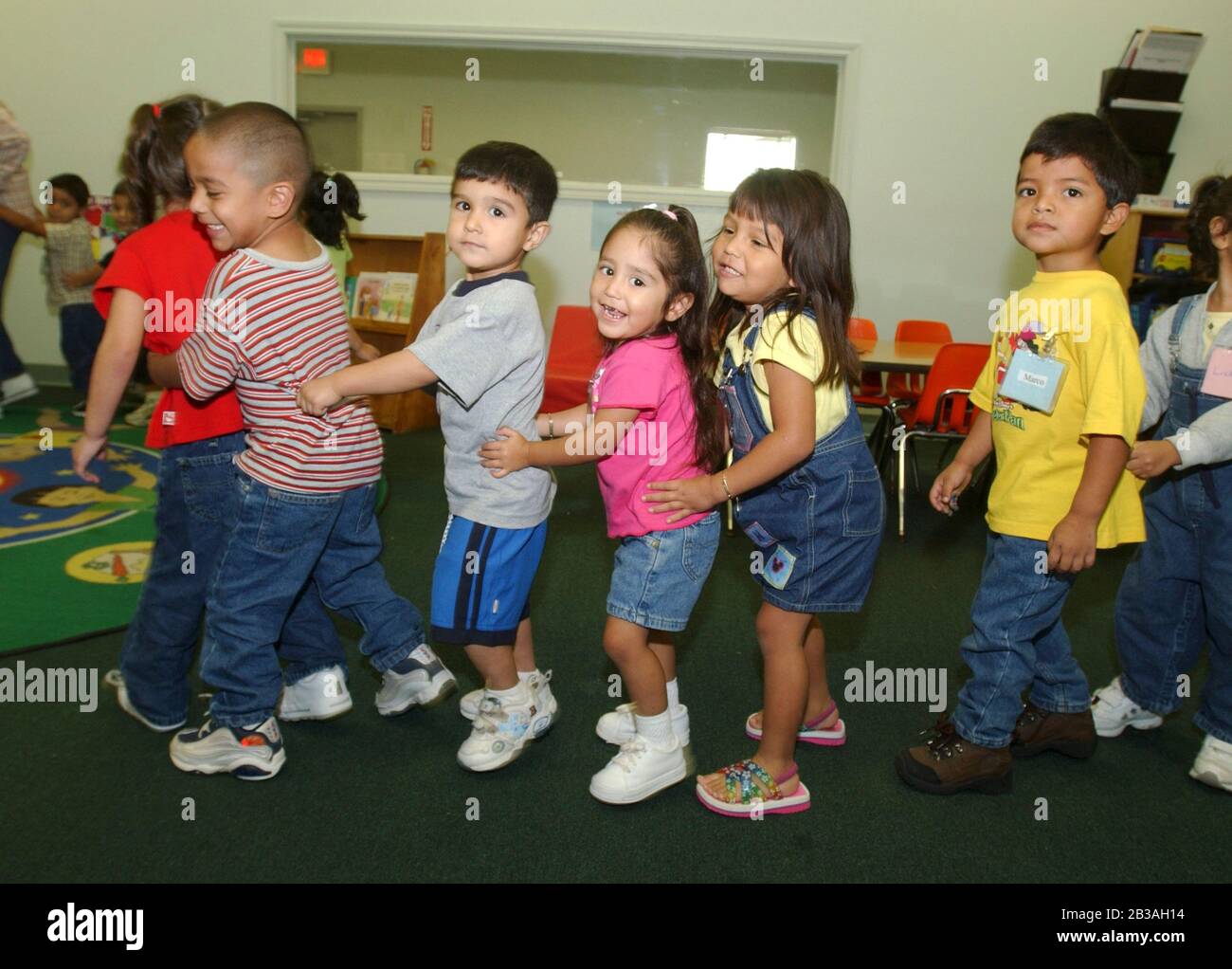 San Benito, Texas 2. Oktober 2002 Kinder aus einkommensschwachen Familien im Rio Grande Valley von Texas bilden eine Linie, während sie im Unterricht in der La Gallina Head Start Einrichtung nördlich von Brownsville, Texas, tanzen. Tausende von Familien werden in den Bezirken Cameron und Willacy mit 38 Schulen für drei- und vierjährige im Rahmen des Head Start-Programms, das von Präsident Lyndon Johnson in den 1960er Jahren ins Leben gerufen wurde, betreut. ©Bob Daemmrich Stockfoto