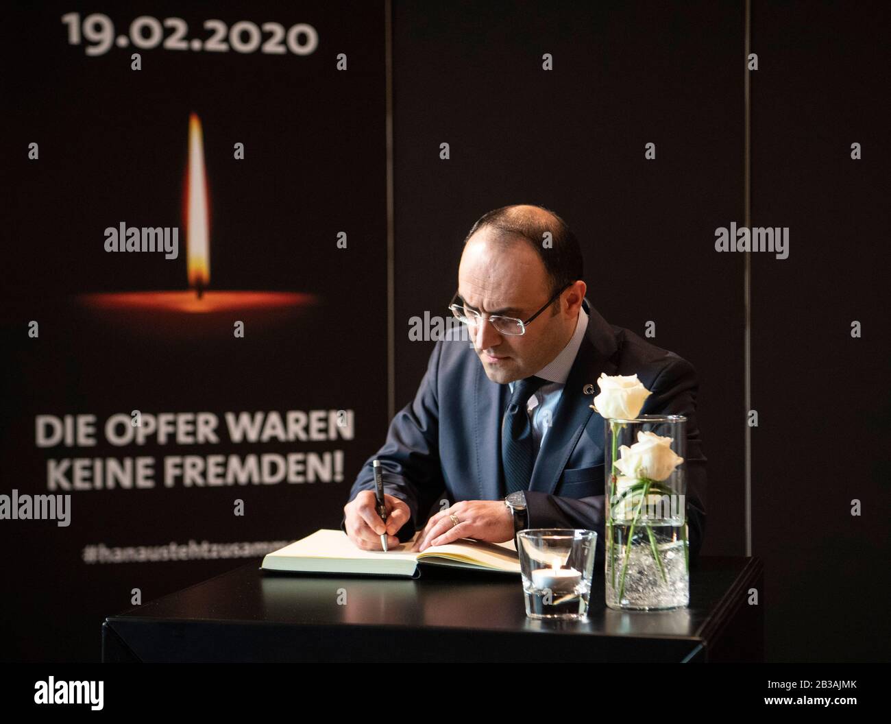 Hanau, Deutschland. März 2020. Burak Kararti, türkischer Generalkonsul, unterzeichnet das Kondolenzbuch bei der Gedenkfeier für die Opfer des Anschlags auf Hanau im Kongresspark Hanau (CPH). Bei dem rassistischen Angriff hatte ein 43-jähriger Deutscher am Abend des 19. Februar neun Menschen mit ausländischen Wurzeln erschossen und getötet. Der Sportmarktsmann soll auch seine Mutter getötet haben, bevor er sich das Leben nahm. Kredit: Boris Roessler / dpa / Alamy Live News Stockfoto