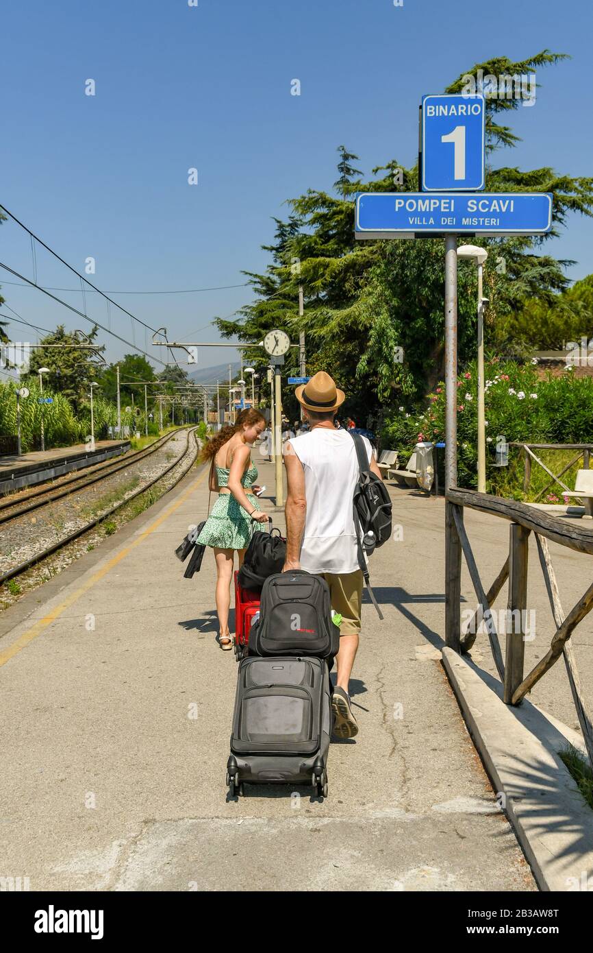 Pompeji, IN DER NÄHE VON NEAPEL, ITALIEN - AUGUST 2019: Person zieht einen Koffer entlang der Plattform 1 der Station Pompeji Scavi Stockfoto