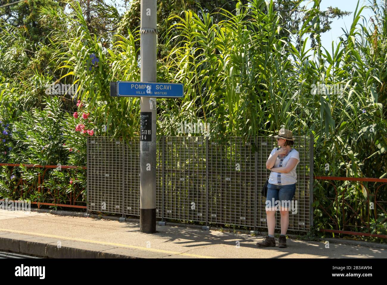 Pompeji, IN DER NÄHE VON NEAPEL, ITALIEN - AUGUST 2019: Person, die auf der Plattform 2 des Bahnhofs Pompeji Scavi wartet, um einen Zug nach Neapel zu nehmen. Stockfoto