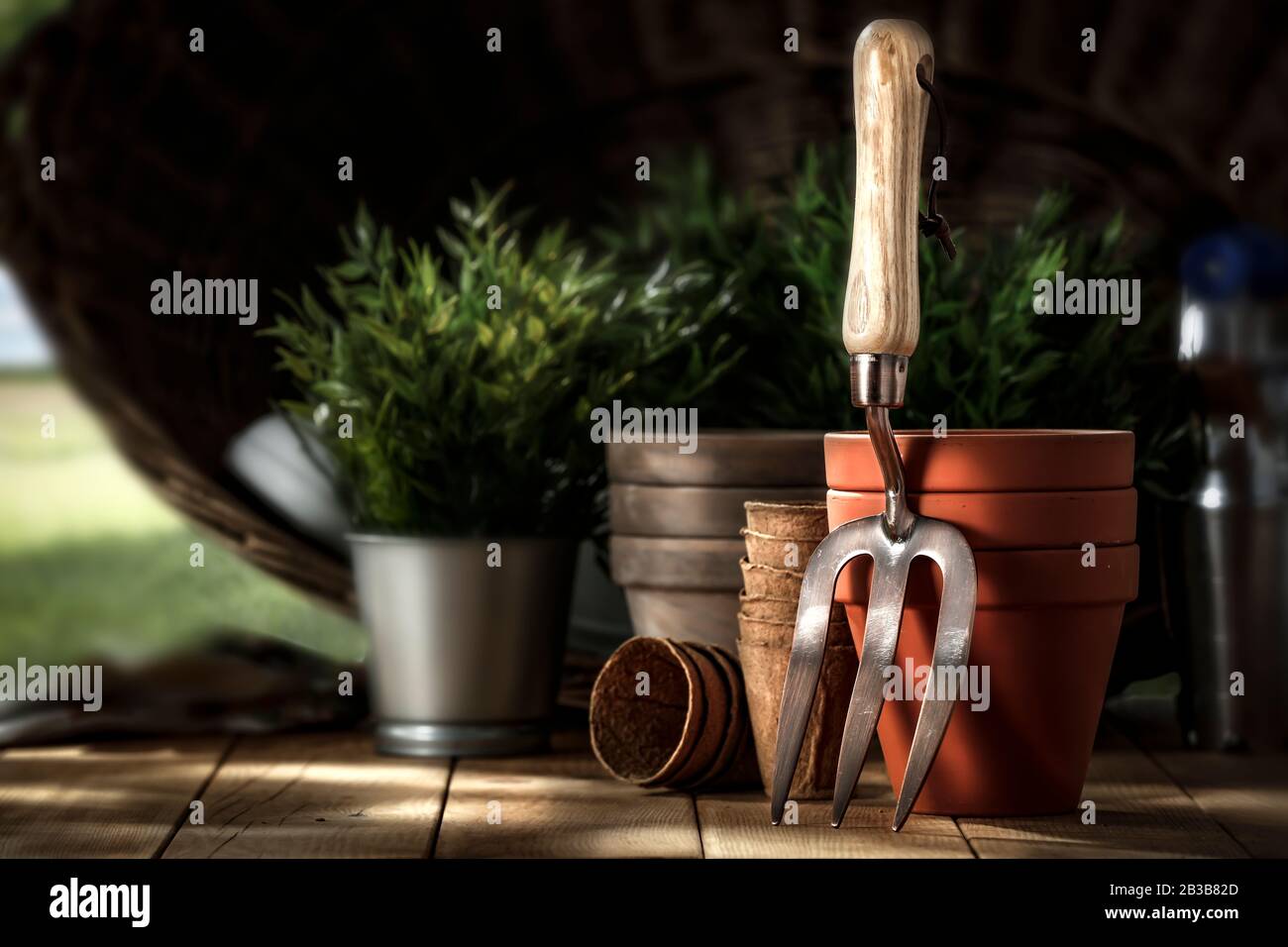 Frühlingszeit im Garten.Gartengeräte mit idyllischem ländlichen Bildhintergrund. Holzbrett mit Gartenwerkzeugen und verschwommenem Hintergrund der Toskana Stockfoto