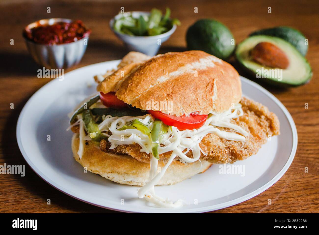 Mexikanischer Torta ist ein milanes-sandwich mit Avocado, Chilischipotle und oaxaca-käse Stockfoto