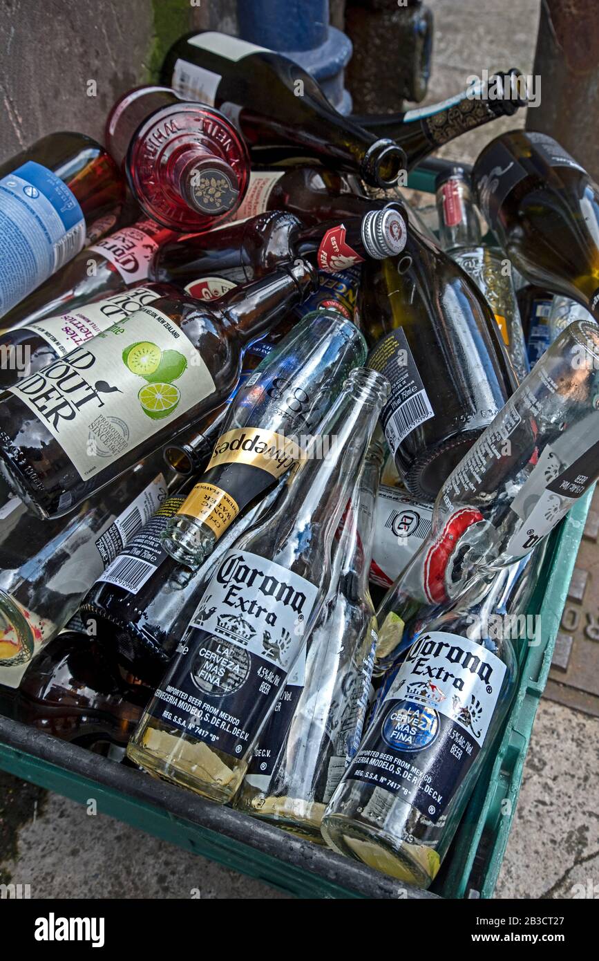 Leere Flaschen in einem Behälter vor einem öffentlichen Haus, die darauf  warten, weggenommen zu werden, um recycelt zu werden Stockfotografie - Alamy