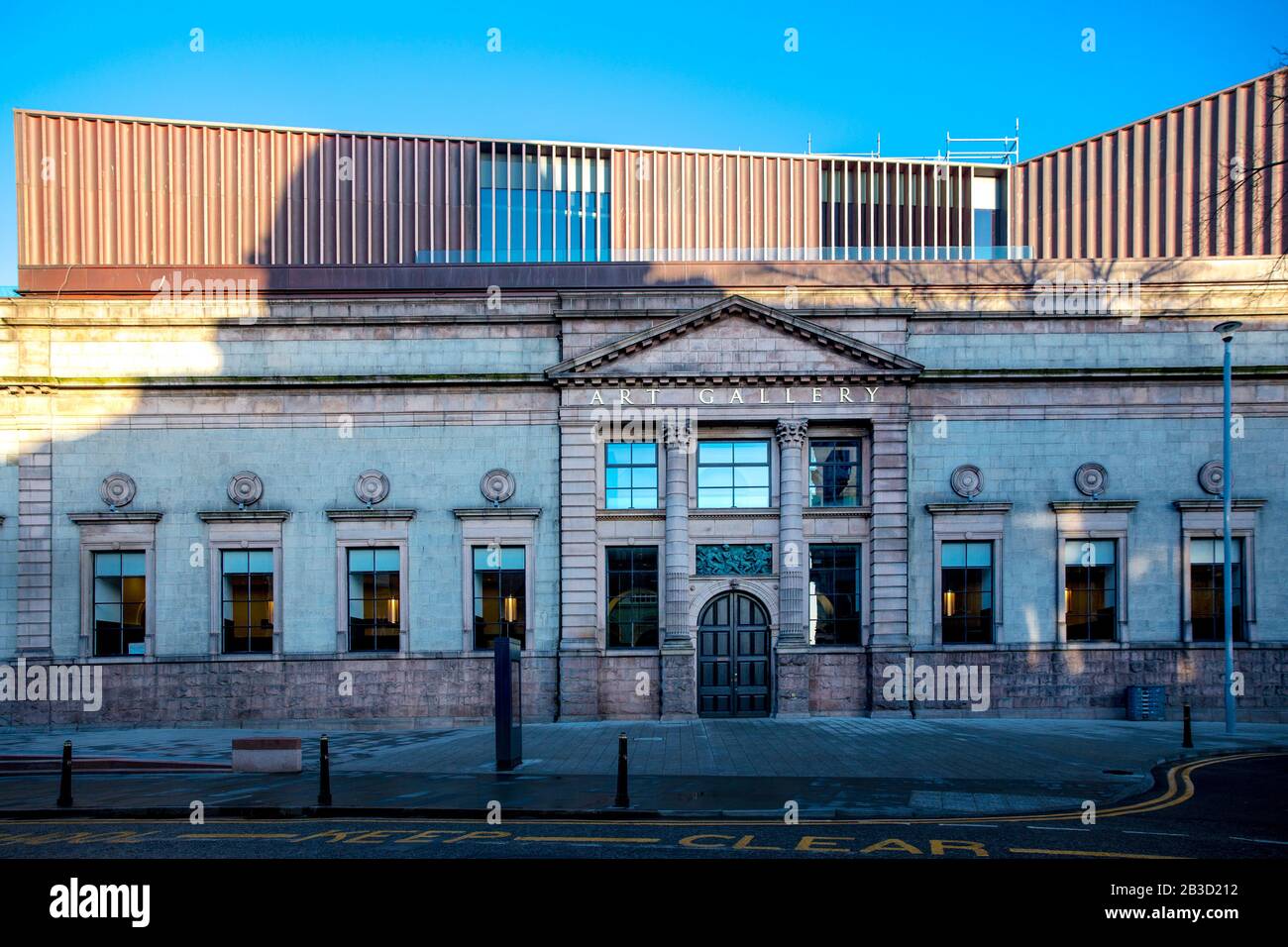 Frontale façade der Aberdeen Art Gallery in Schottland, gebadet im frühen Morgenlicht, mit einem hellen pantone blauen Himmel im Hintergrund. Stockfoto