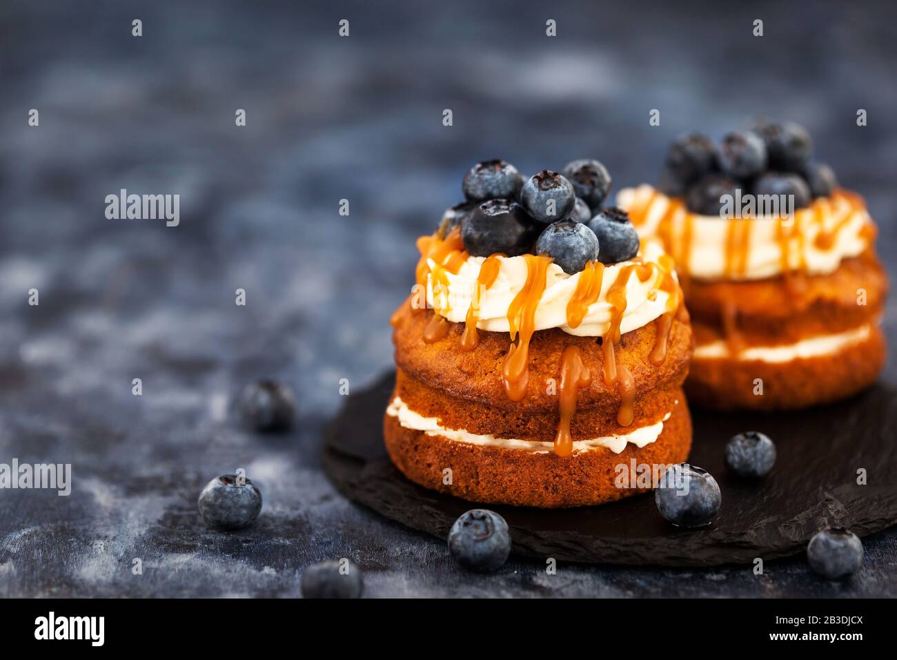 Hausgemachte Karotten individuelle Kuchen mit Karamellsoße, Frischkäse und frischen Blaubeeren Stockfoto