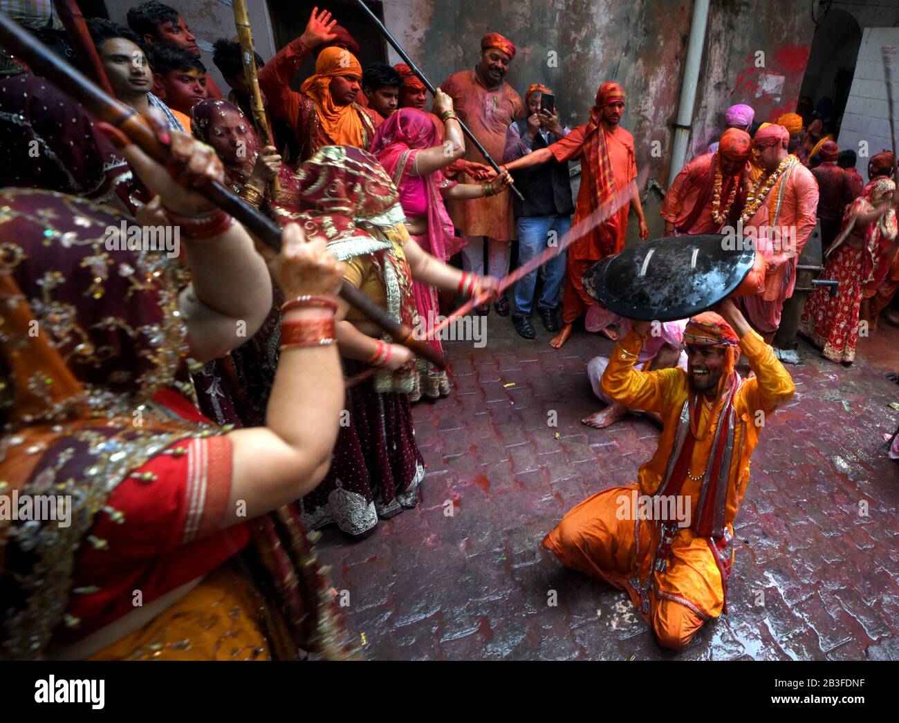 Ein Hindu-Mann, der von Frauen mit Stock bei Barsana geschlagen wurde, nannte sich Lathmar holi. Das Festival begann 1 Woche vor dem eigentlichen Holi-Datum. Der Mythos hinter diesem Lathmar Holi steht im Zusammenhang mit dem Hindu-Gott Lord Krishna, der gemäß dem lokalen Glauben aus seiner Heimatstadt Nandgaon an seinen Lovers Place bei Barsana kam und Radha und ihre Freunde neckte. Mit diesem gemeinsamen Glauben seit mehr als 100 Jahren pflegen Frauen von Barsana immer noch das Ritual und schlagen die Außenseiter von Nandgaon mit Stöcken (Lathi), um die Tradition an diesem bestimmten Tag aufrechtzuerhalten. Stockfoto