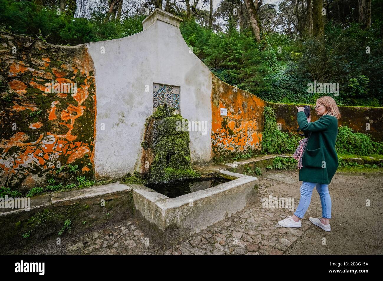 Ein weiblicher Touristenhalt am Brunnen, um ein Foto im Pena Palace Sintra Portugal zu machen Stockfoto