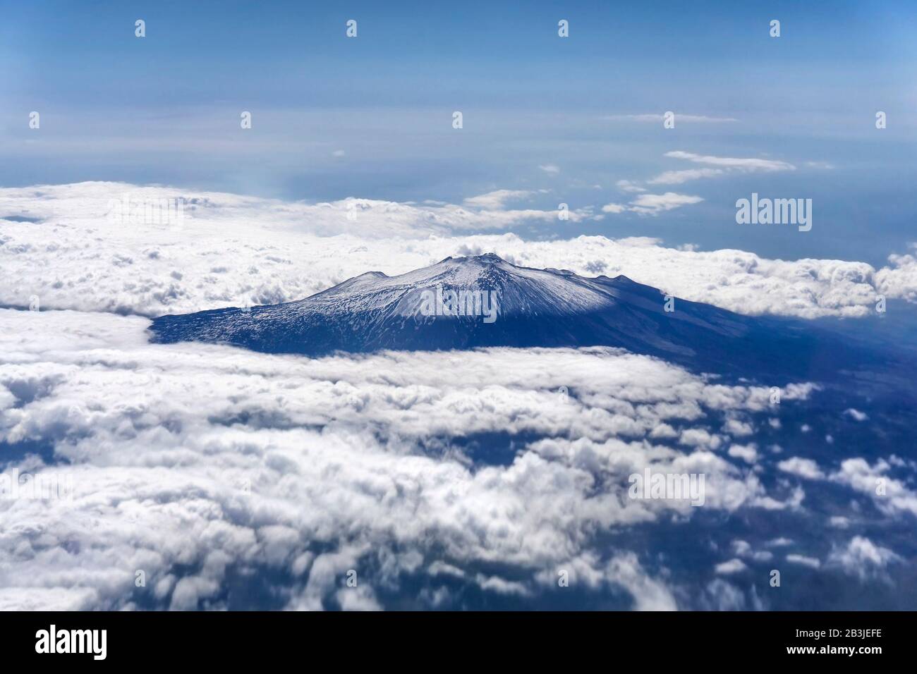 Der Vulkan Ätna ist schneebedeckt. Blick von der Ebene durch Wolken Stockfoto