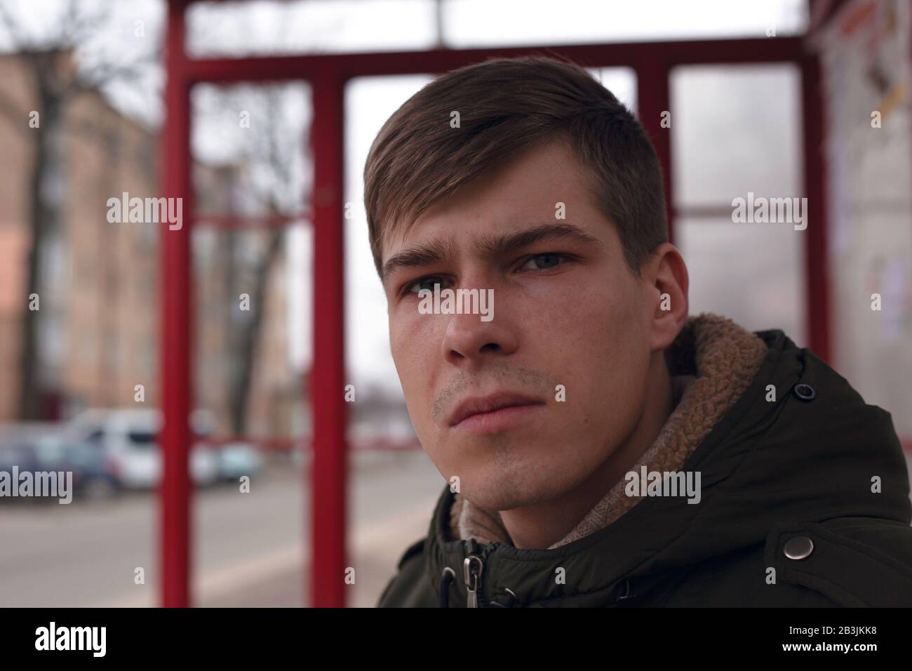 Porträt eines jungen Kerls 21-22 Jahre alt in der Nähe eines Busbahnhofs. Stockfoto