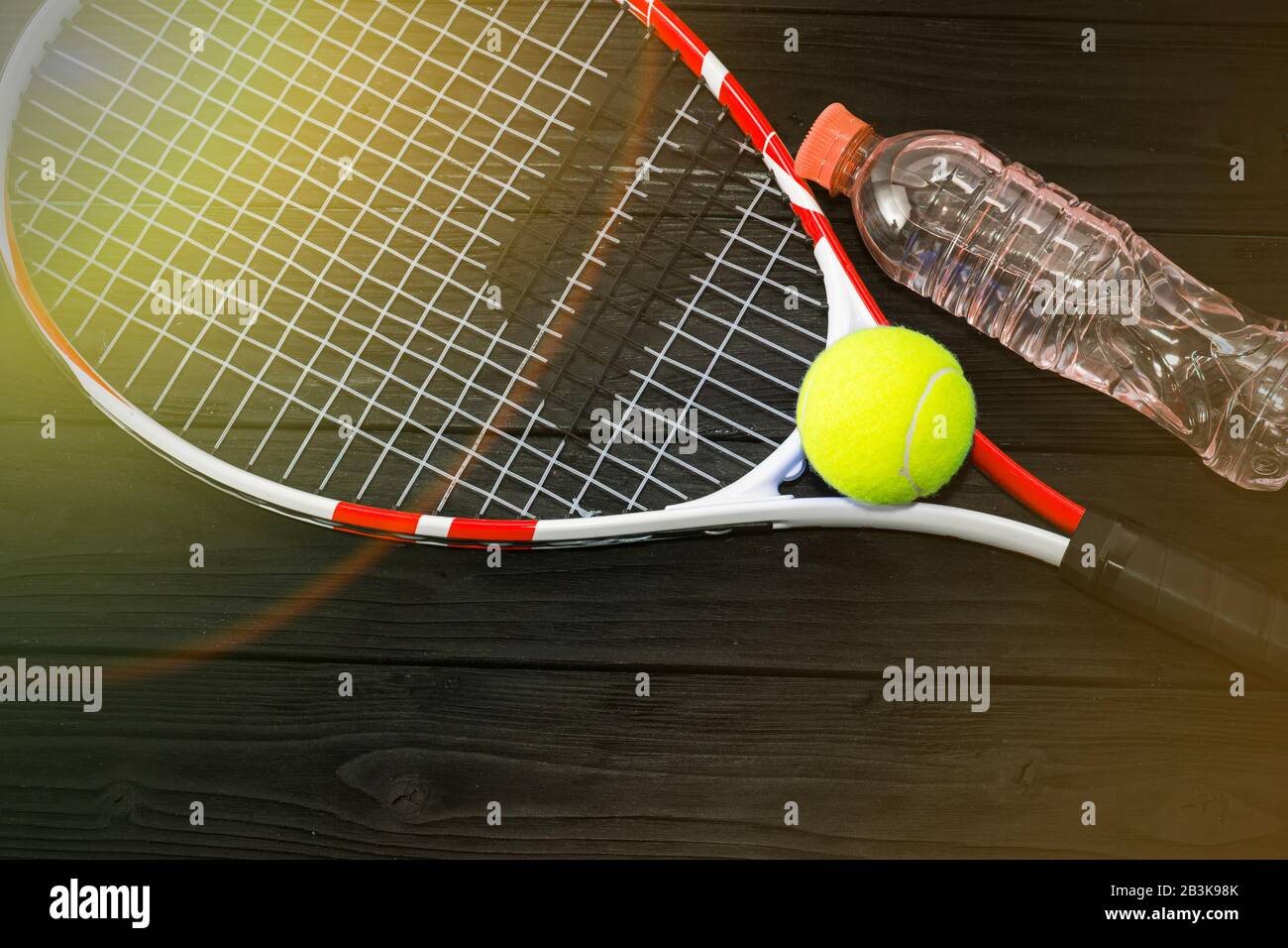 Tennis auf schwarzem Holzhintergrund, Tennisschläger, Ball Stockfoto