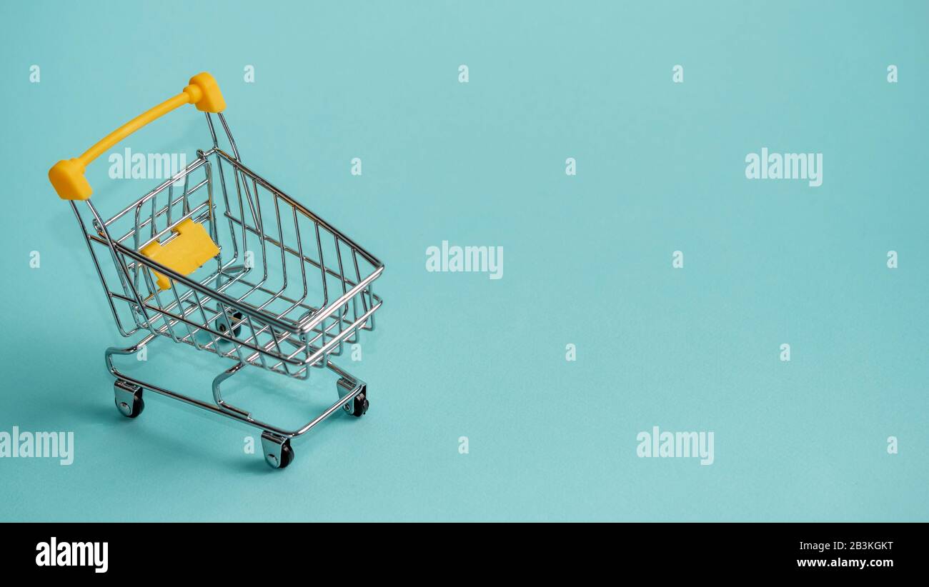 Warenkorb auf blauem Hintergrund. Shop Einkaufswagen im Supermarkt als Verkauf, Rabatt, shopaholism Konzept mit Kopie Platz für Text oder Design. Stockfoto