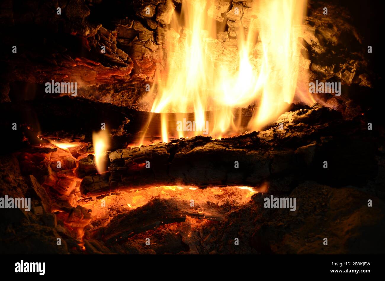 Kamin auf dem Land; Holzfeuer aus Eiche mit Flammen und Glut. Stockfoto