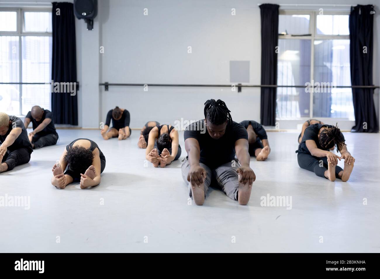 Mixed Race moderne Tänzerinnen, die sich in einem Studio ausdehnen Stockfoto