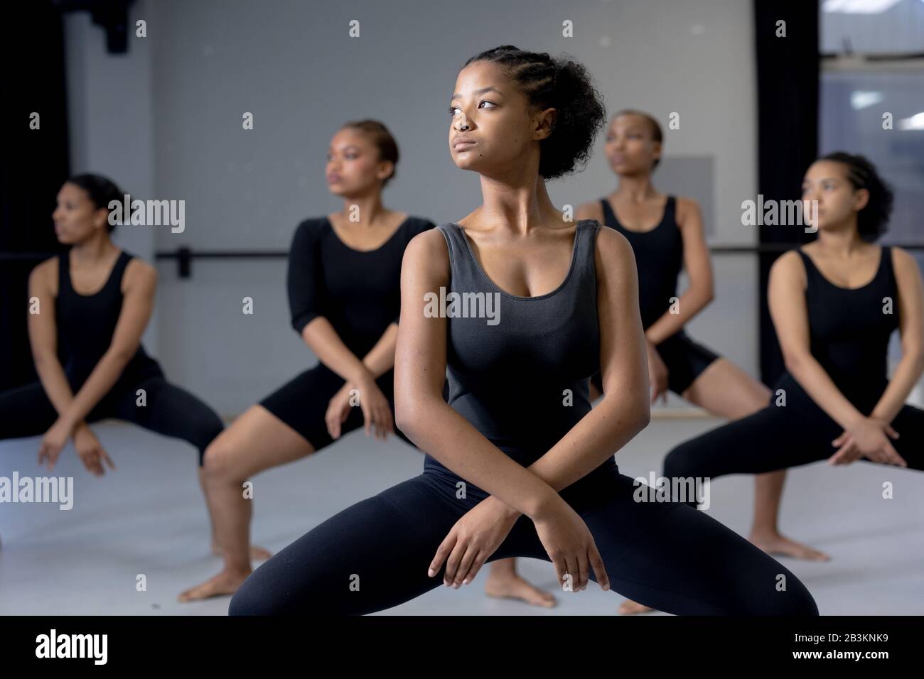 Gruppe von Tänzerinnen, die in einem Studio eine Tanzroutine praktizieren Stockfoto